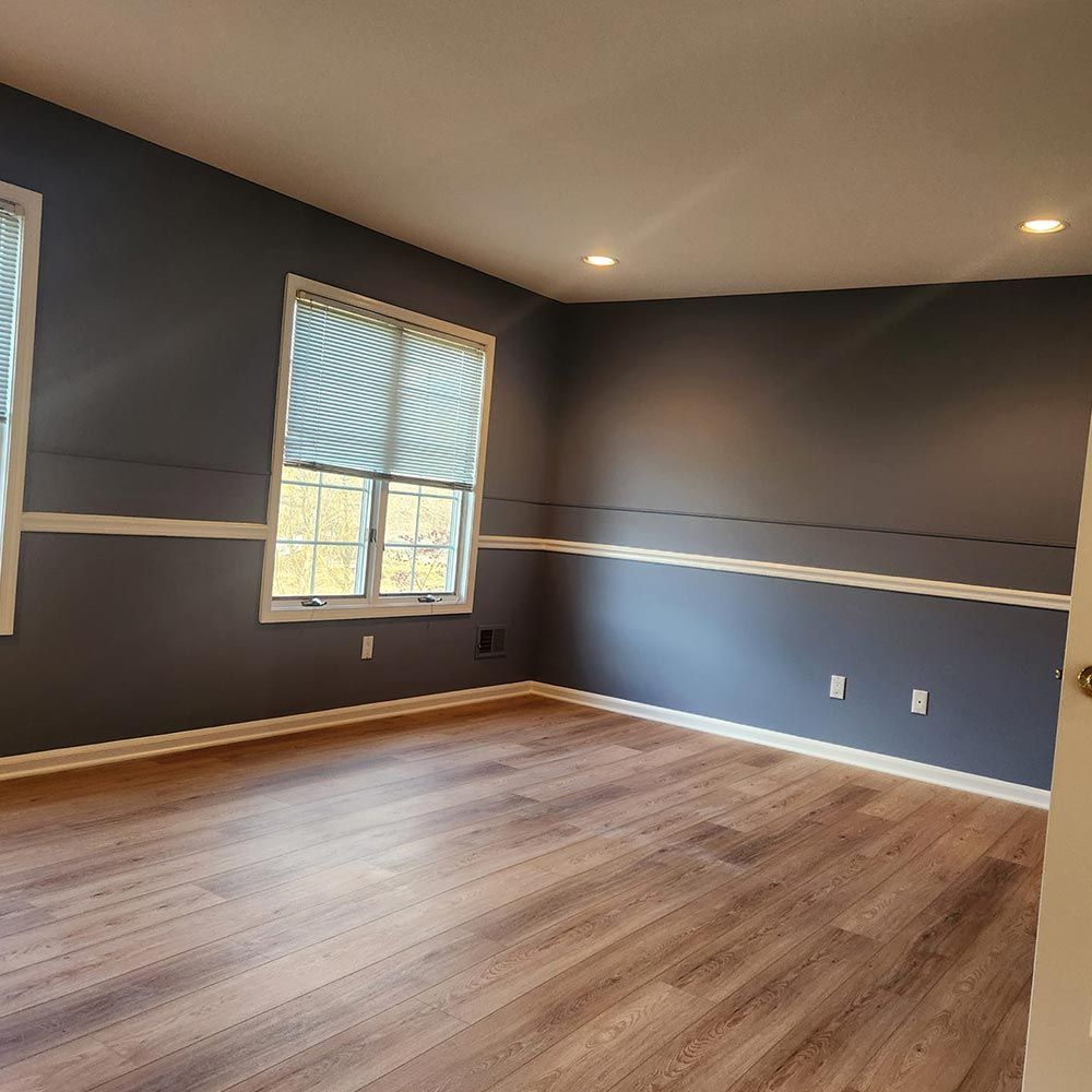 A large empty room with hardwood floors and blue walls.