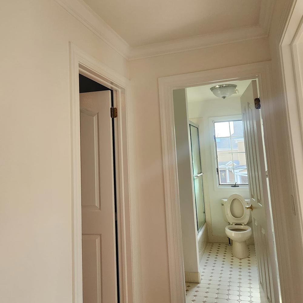 A hallway leading to a bathroom with a toilet