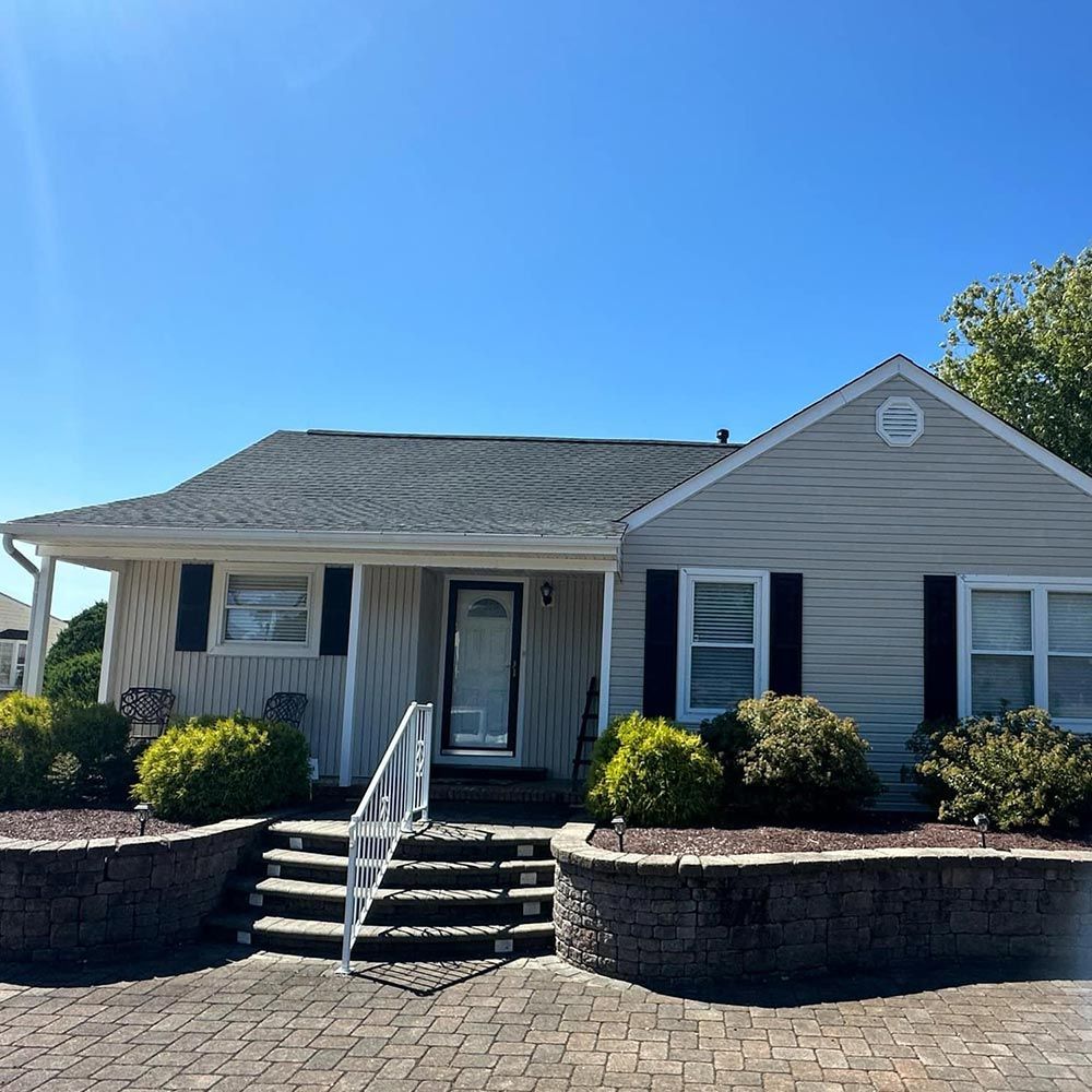 A white house with black shutters and stairs