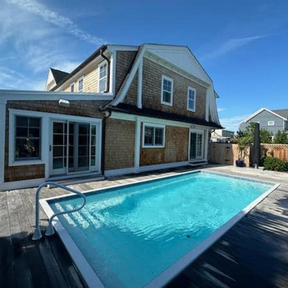 A large house with a large swimming pool in front of it.