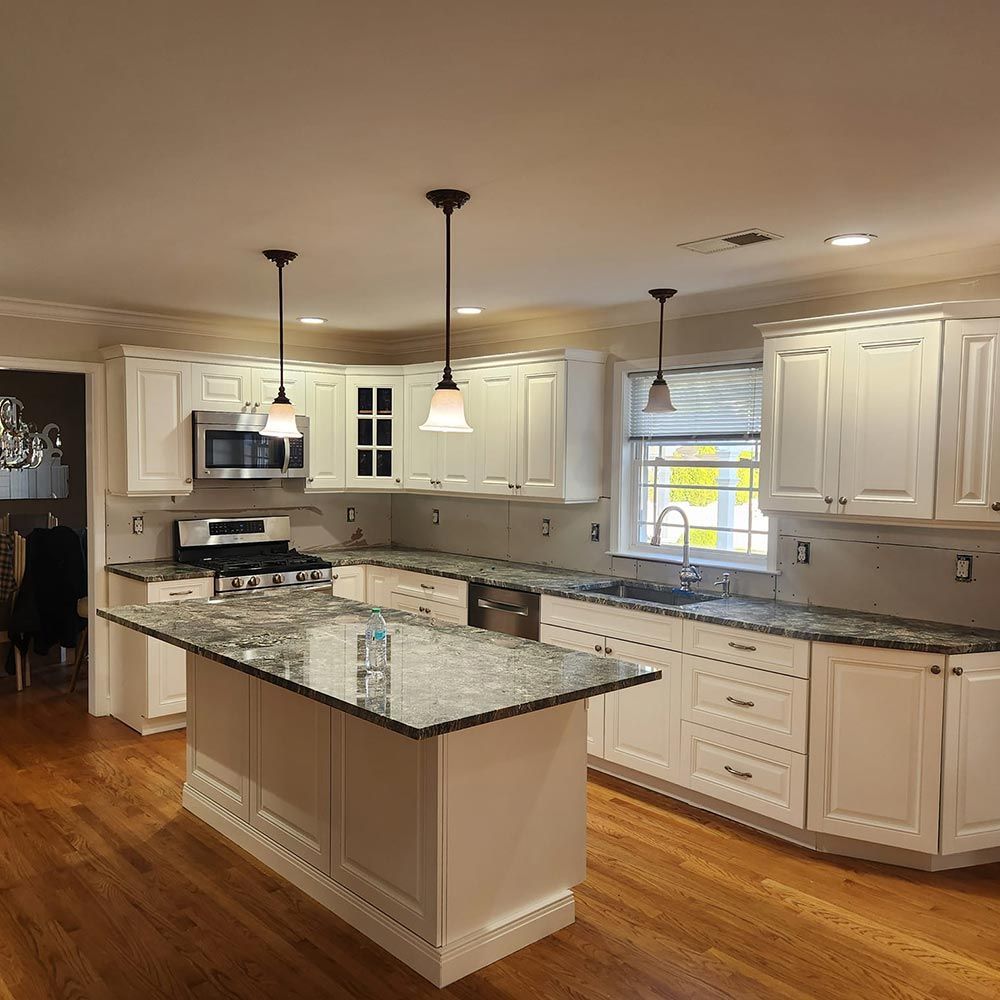 A kitchen with white cabinets and granite counter tops