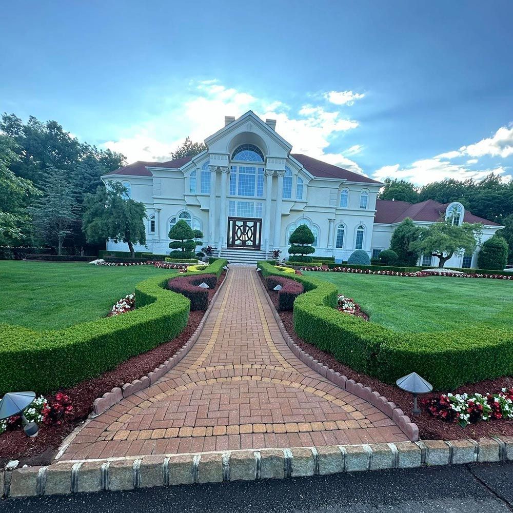 A large white house with a brick walkway leading to it