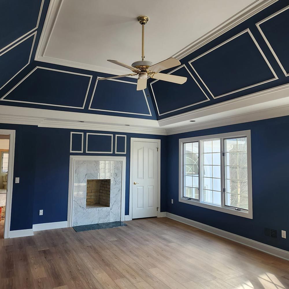 A living room with blue walls and a ceiling fan
