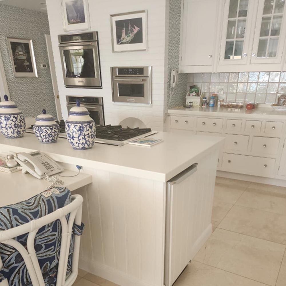 A kitchen with white cabinets and a stove top oven