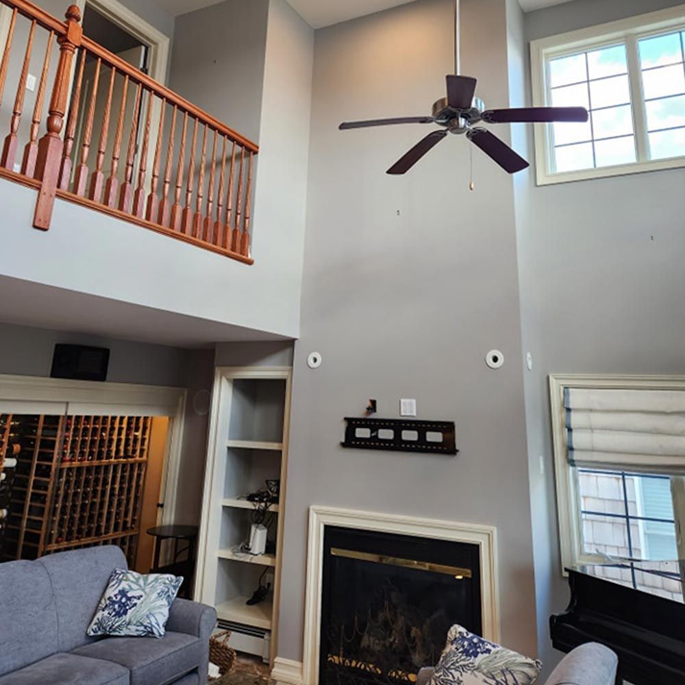 A living room with a fireplace and a ceiling fan