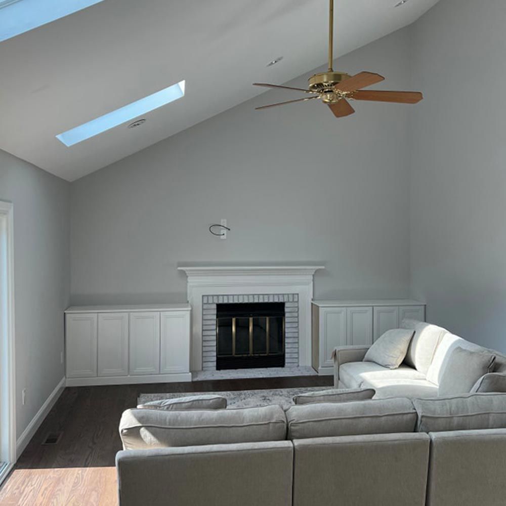 A living room with a fireplace and a ceiling fan