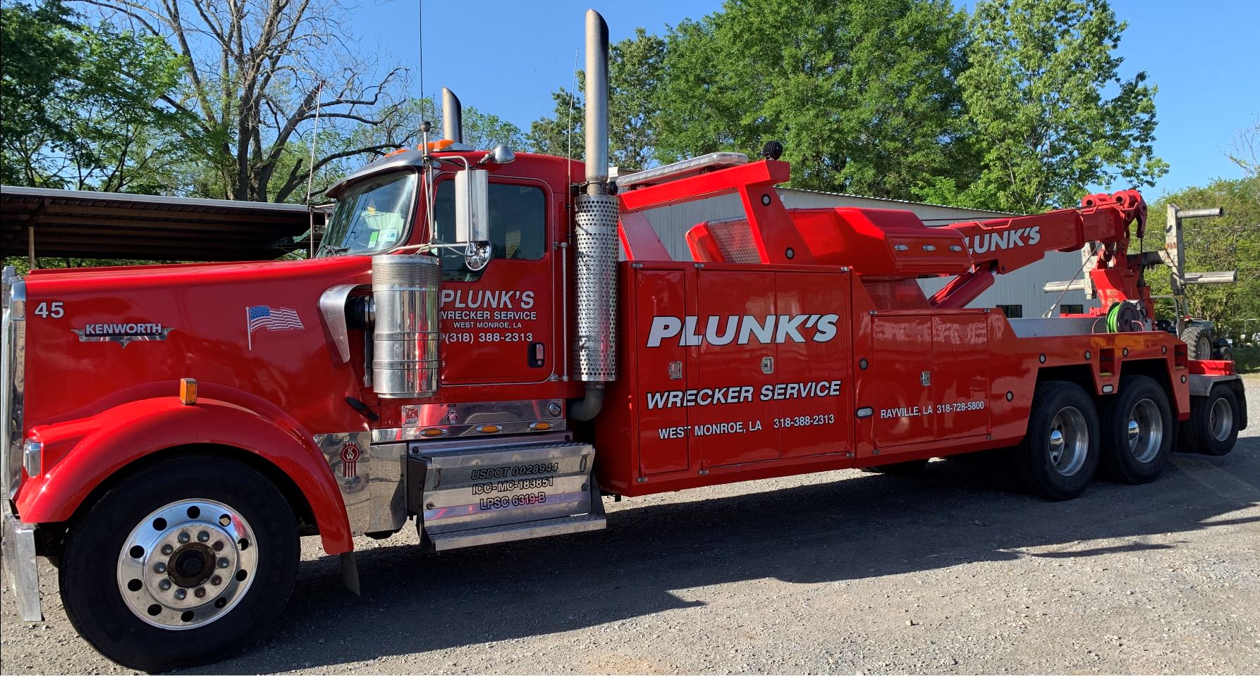 A red tow truck that says plunk 's on the side