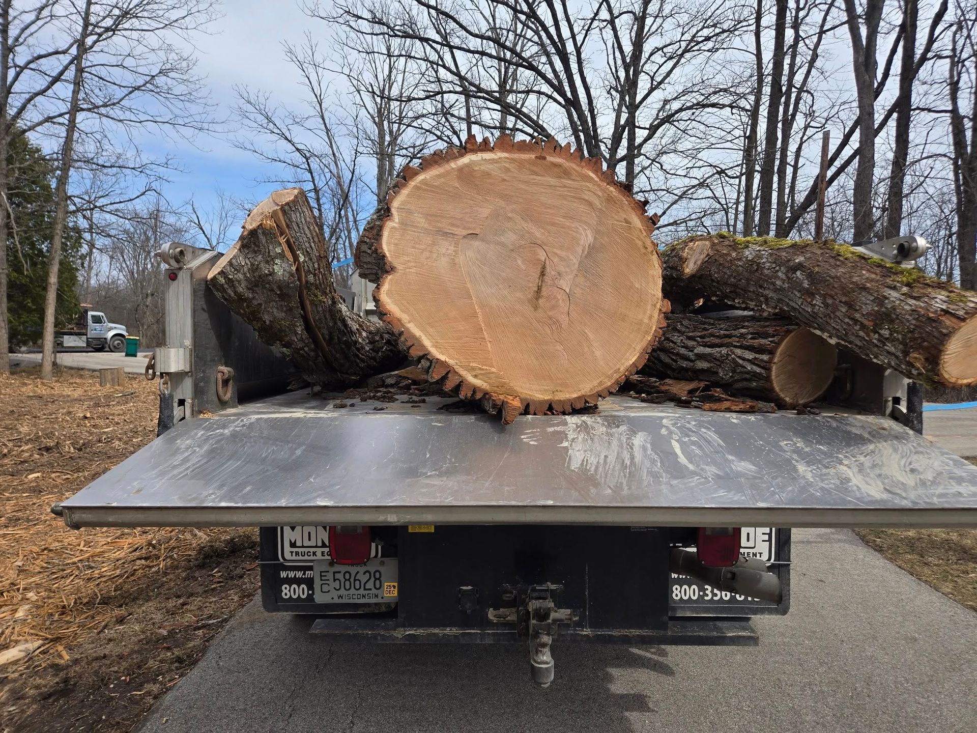 A large log is sitting on the back of a truck