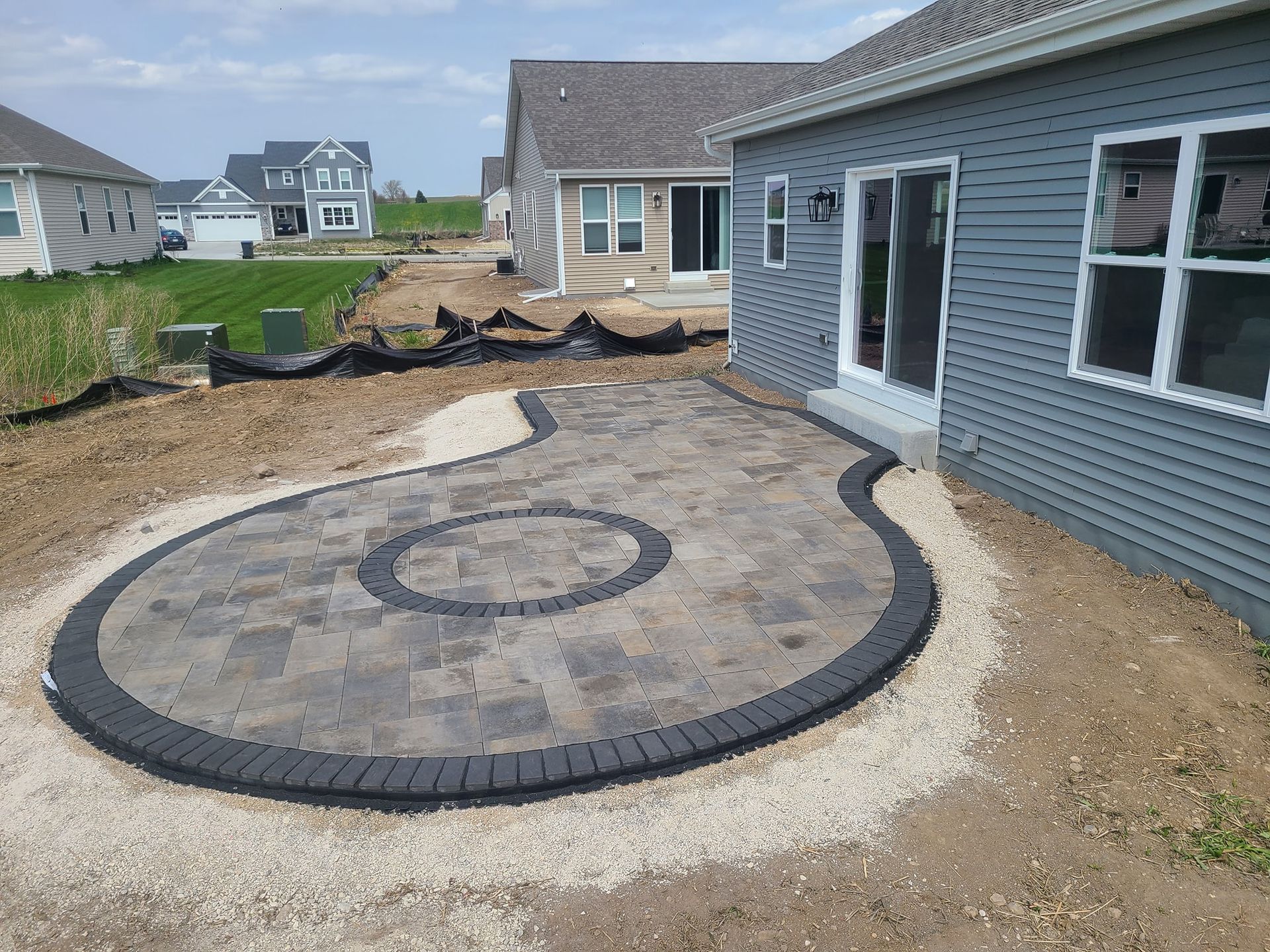 A circular patio is being built in front of a house.