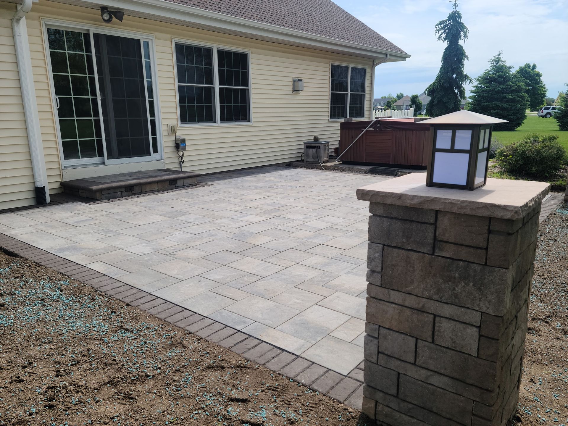 A house with a patio and a hot tub in the backyard.