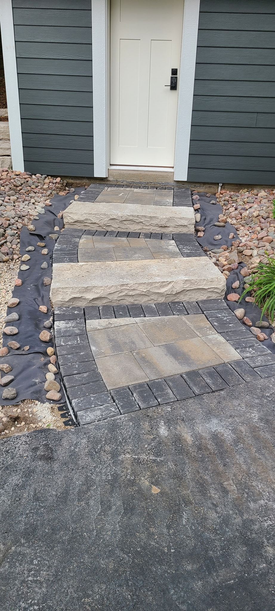 A stone walkway leading to the front door of a house.