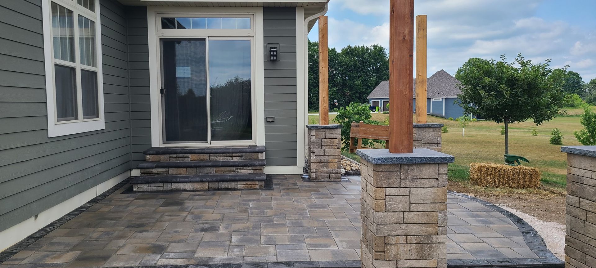 A house with a patio and a pergola in front of it.