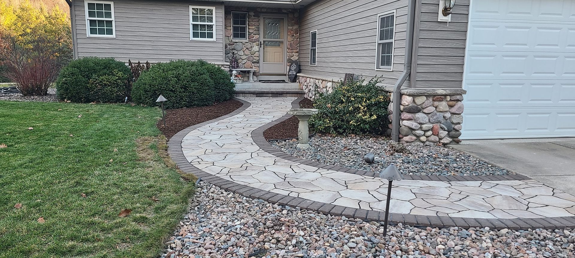 A stone walkway leading to the front door of a house.