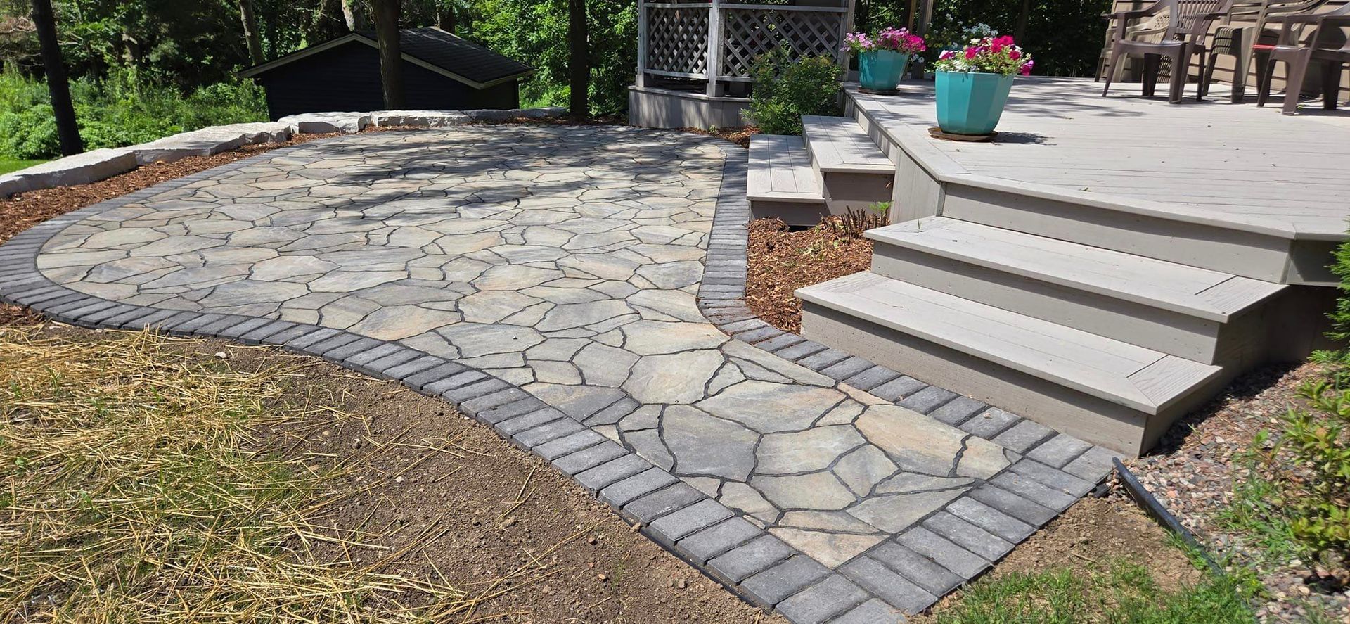 A patio with steps and a gazebo in the background.