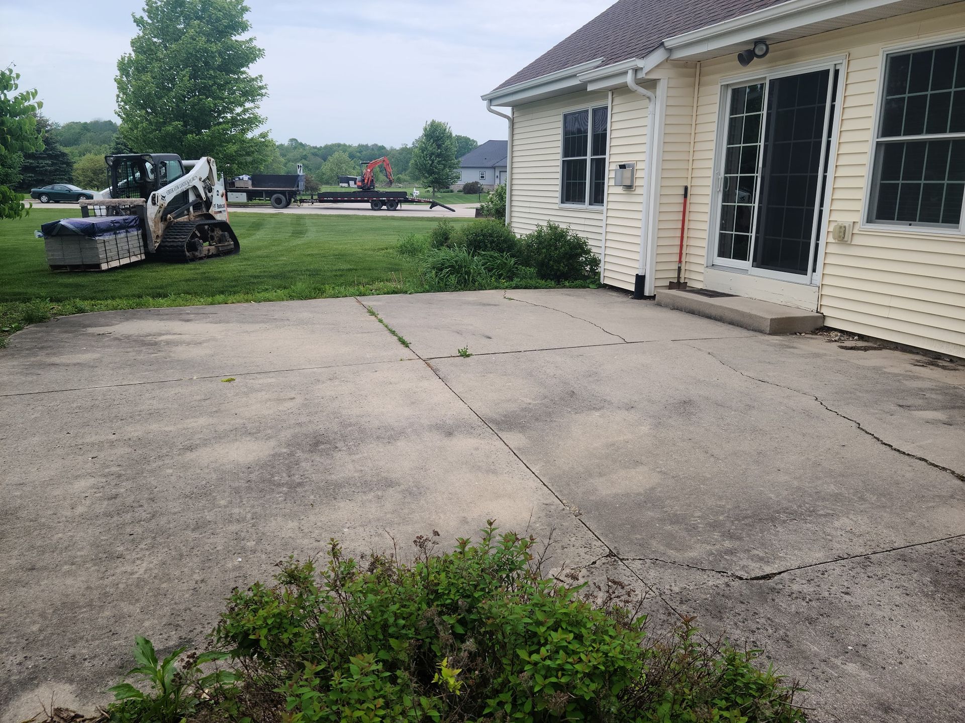 A bobcat is parked in front of a house