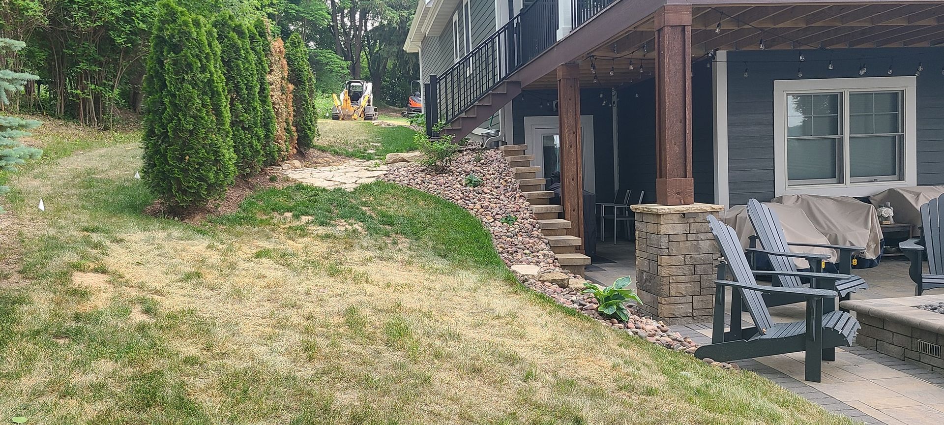 A house with a patio and chairs in front of it.