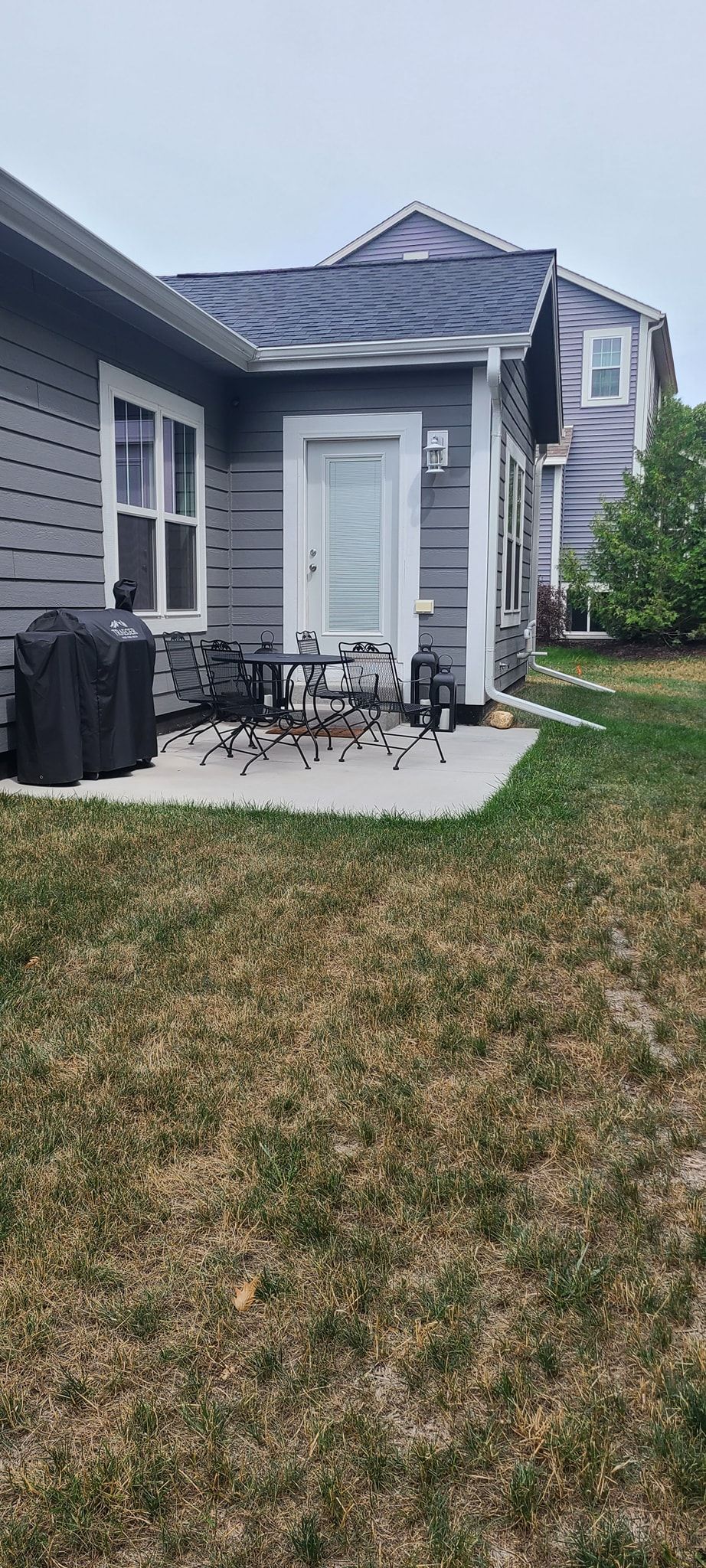A house with a patio and chairs in front of it.