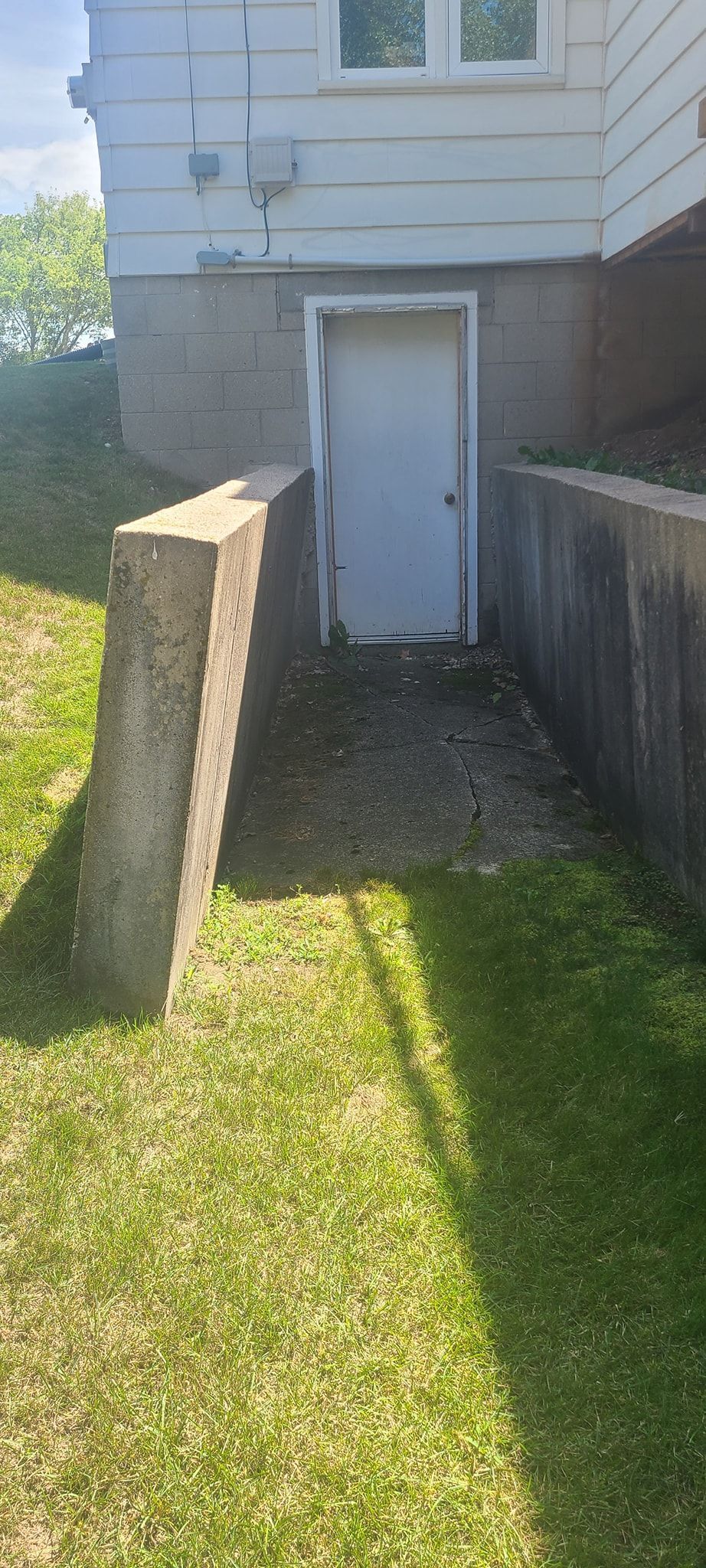 There is a white door in the backyard of a house.