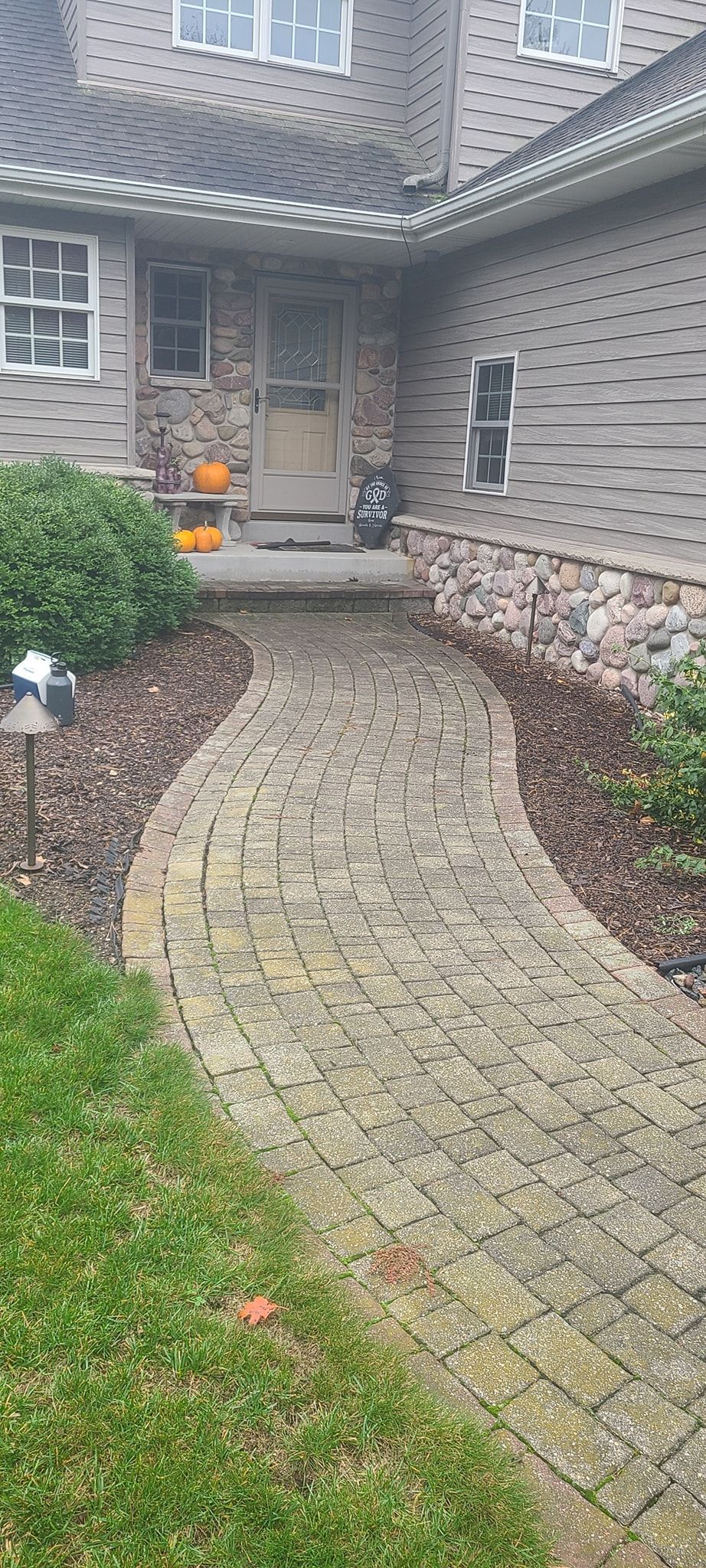 A brick walkway leading to the front door of a house.