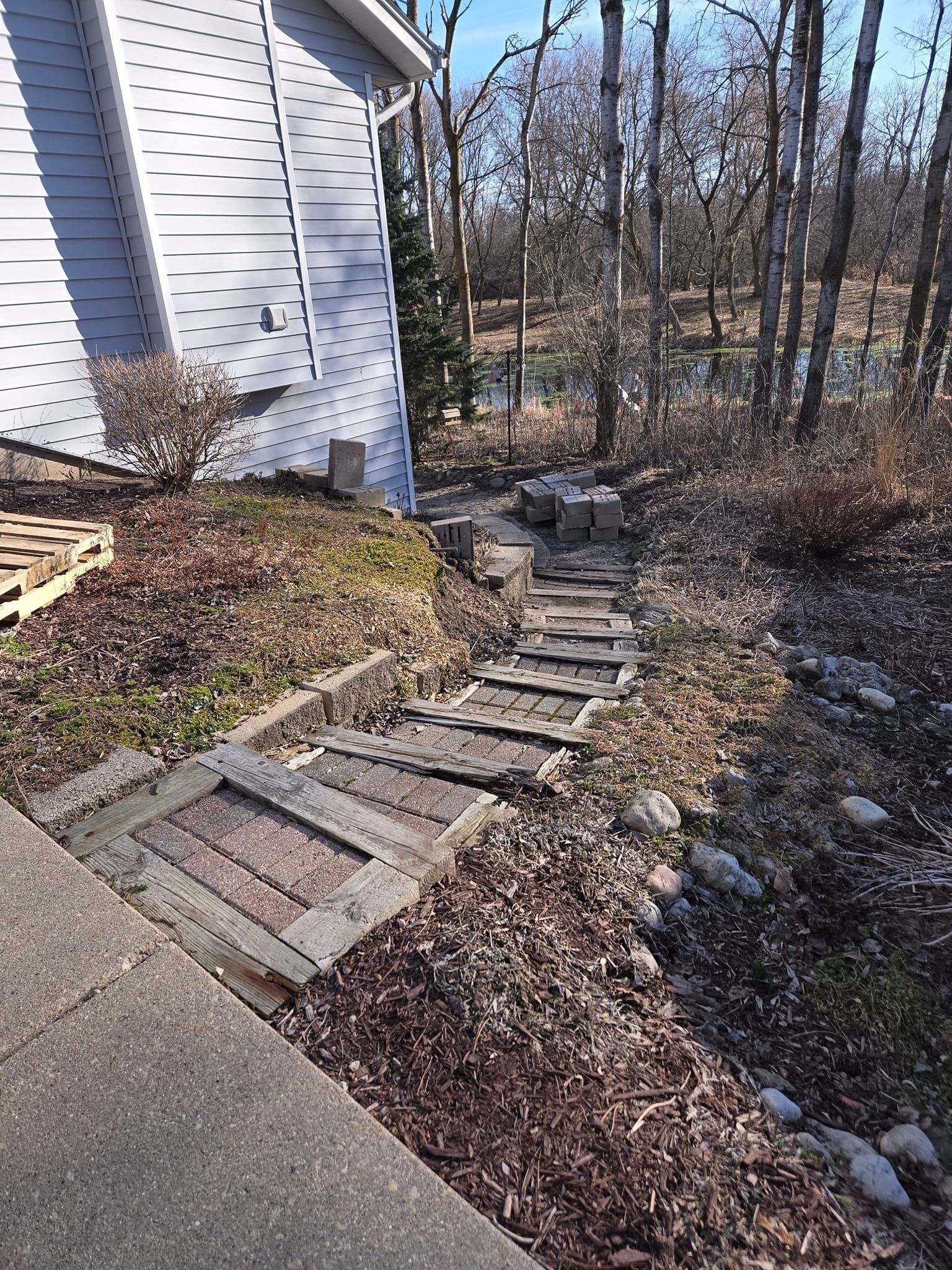 A wooden walkway leading to a house in the woods.
