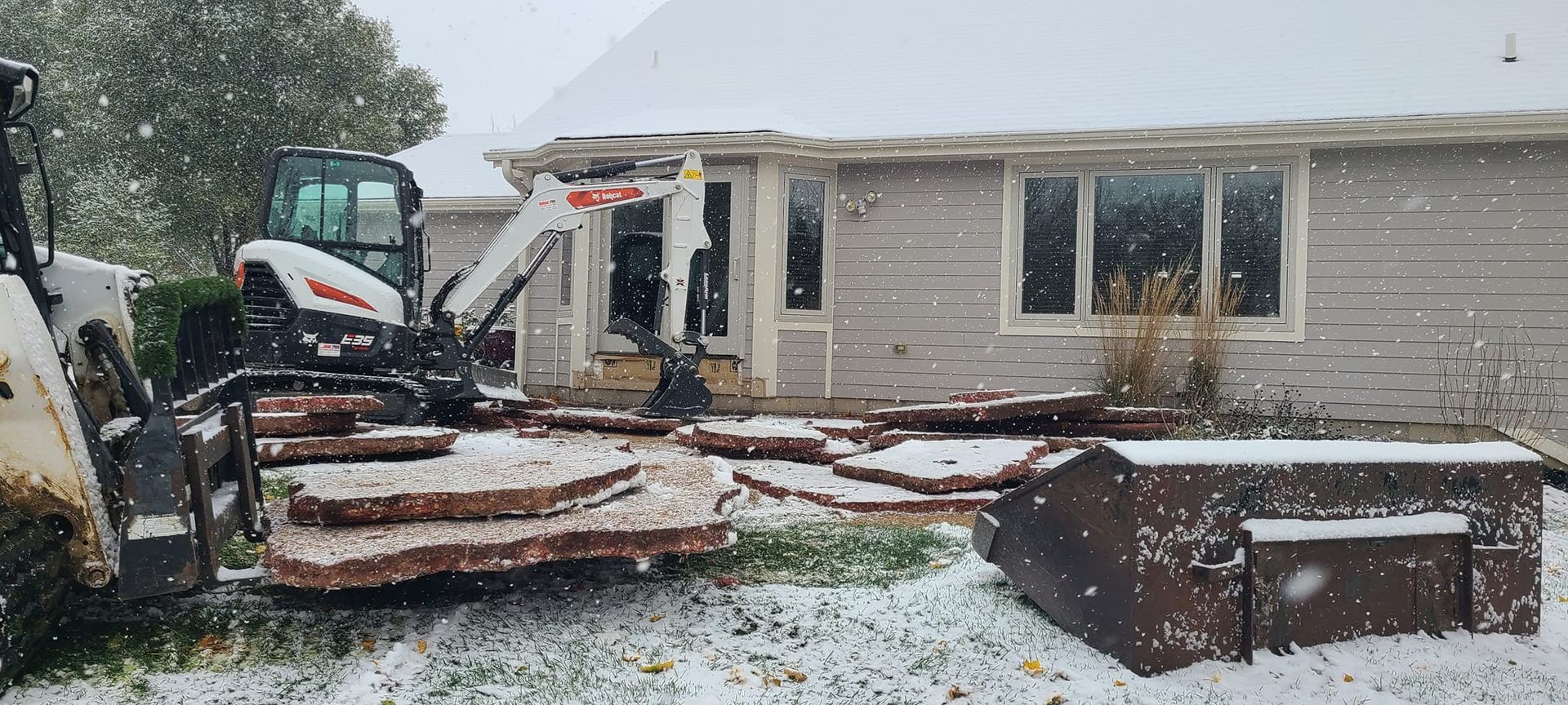 A house with a lot of snow on the ground in front of it.