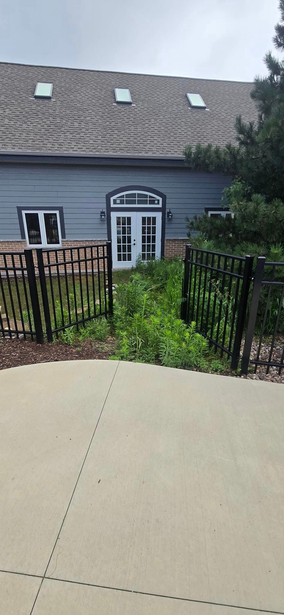 A house with a fence around it and a driveway leading to it.