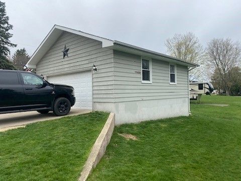 A black truck is parked in front of a garage.