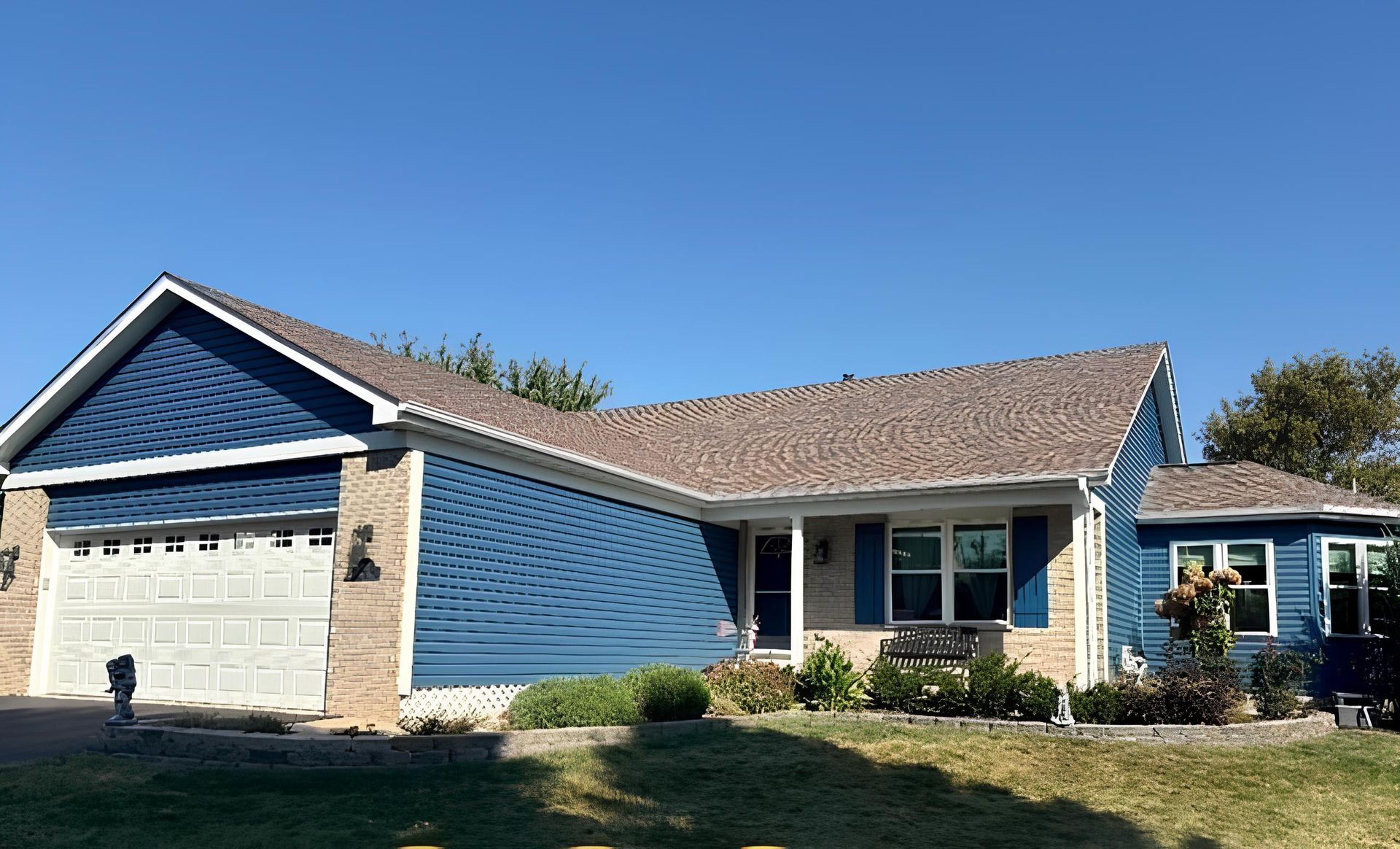 A house with blue siding and a large garage - After