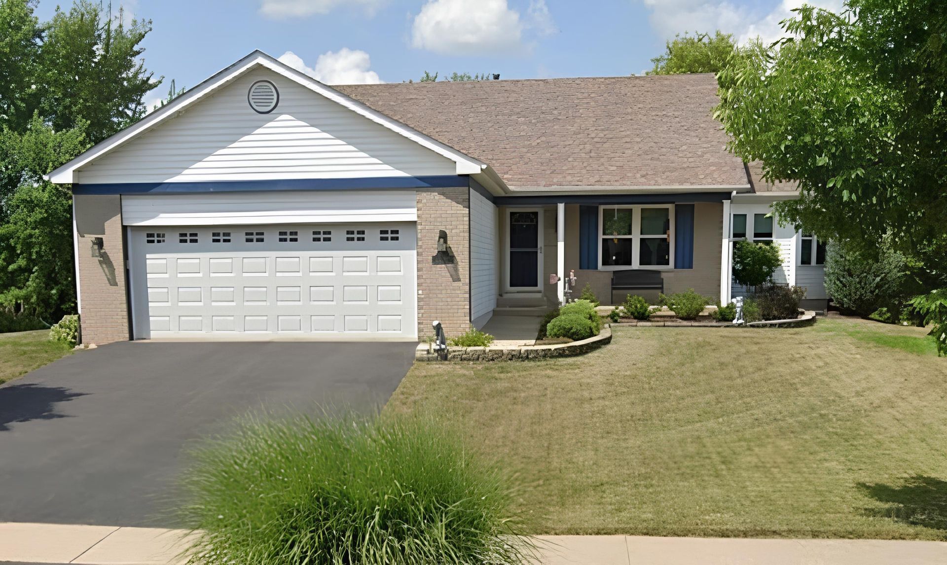 A house with white siding  and a large garage - Before