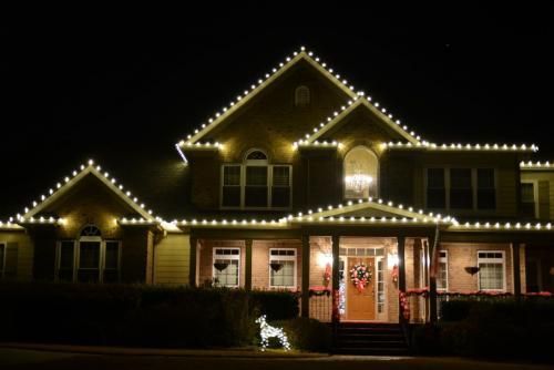 House decorated with white Christmas lights at night
