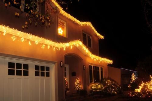 House decorated with yellow Christmas lights against a black night sky
