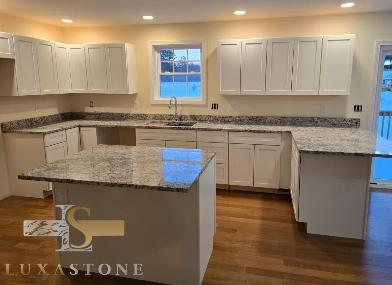 Kitchen with white cabinets, granite countertops, and an island, with wood floors.