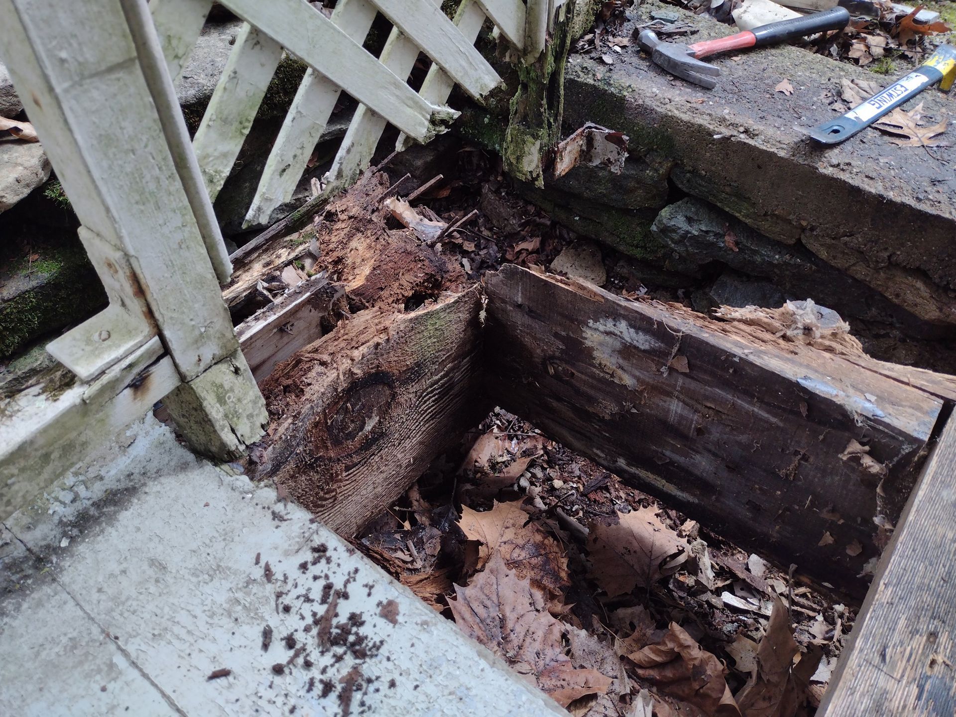 A broken old wooden flooring next to a fence