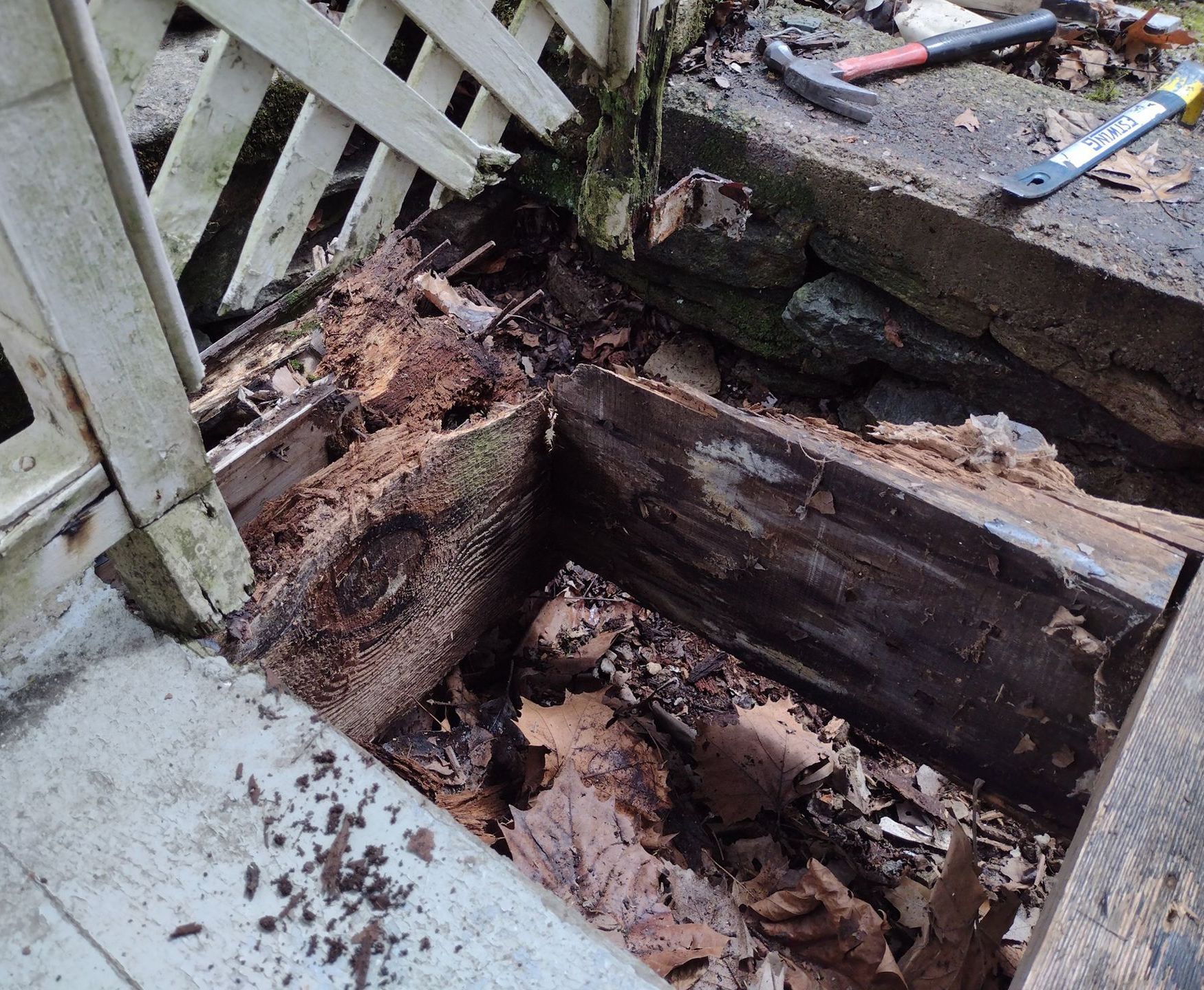 A broken old wooden flooring next to a fence