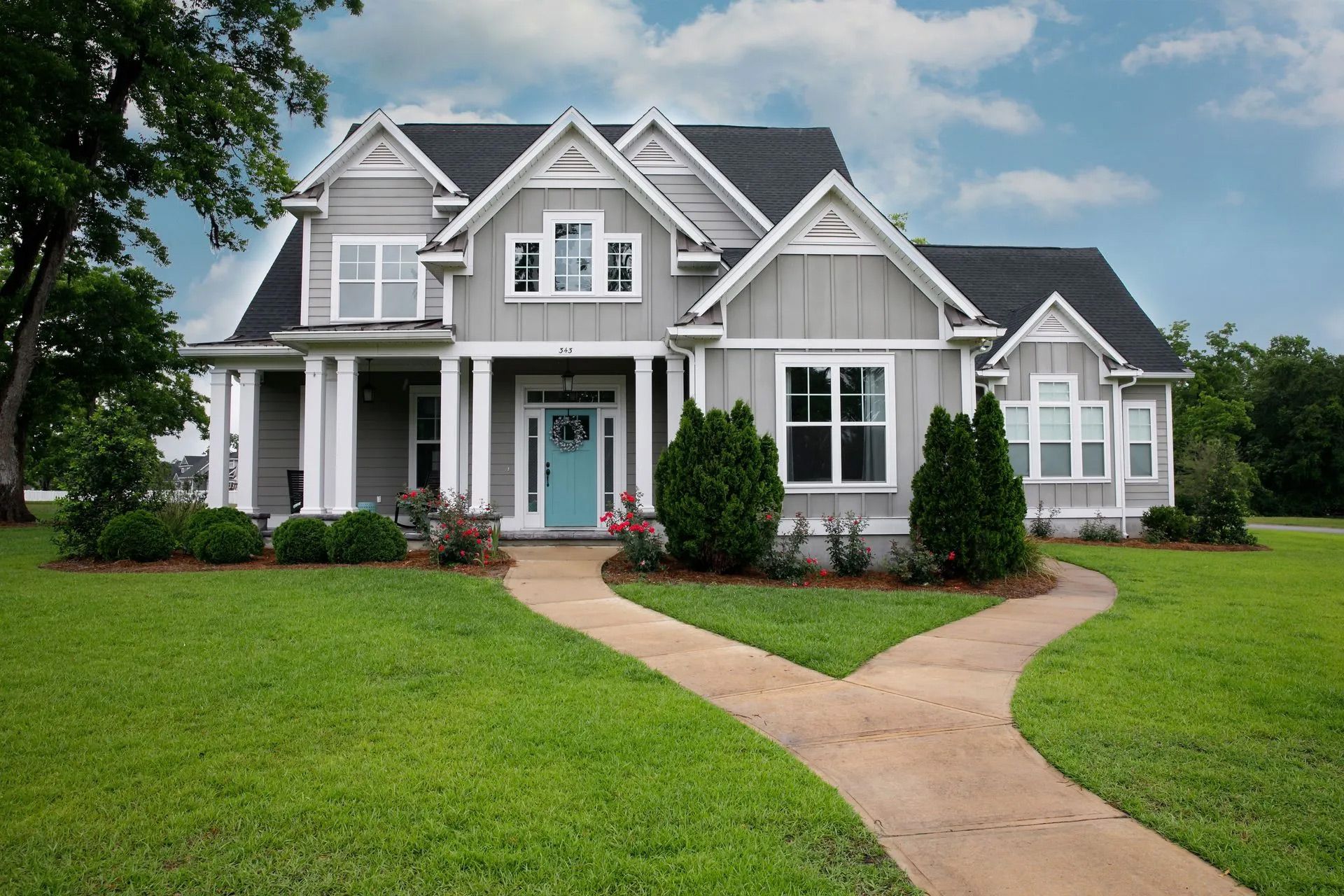 A large house with a blue door and a walkway leading to it