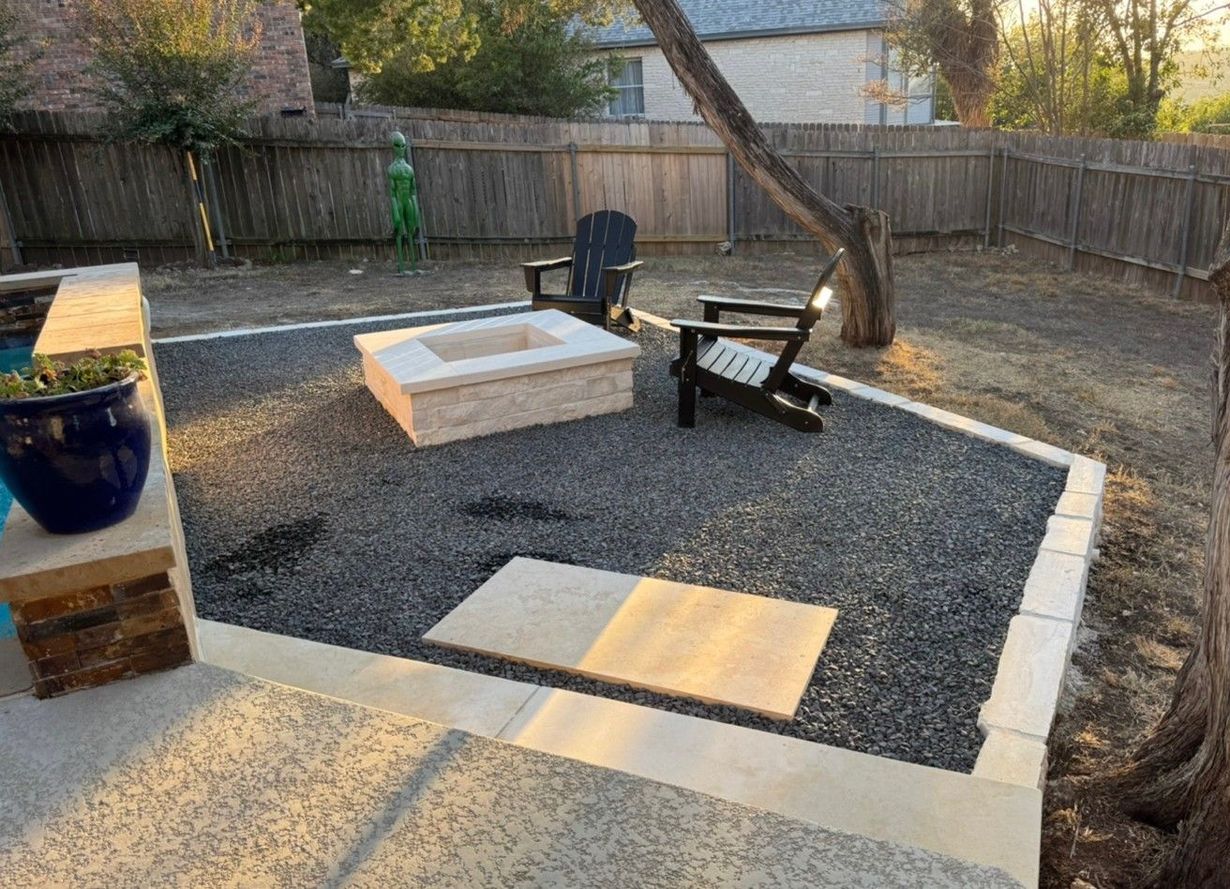 Stone raised garden bed with colorful flowers and green plants.