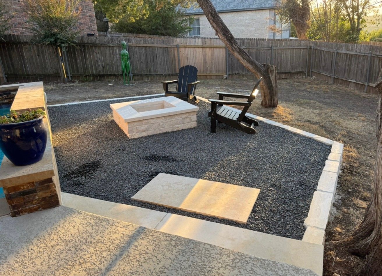 Stone raised garden bed with colorful flowers and green plants.
