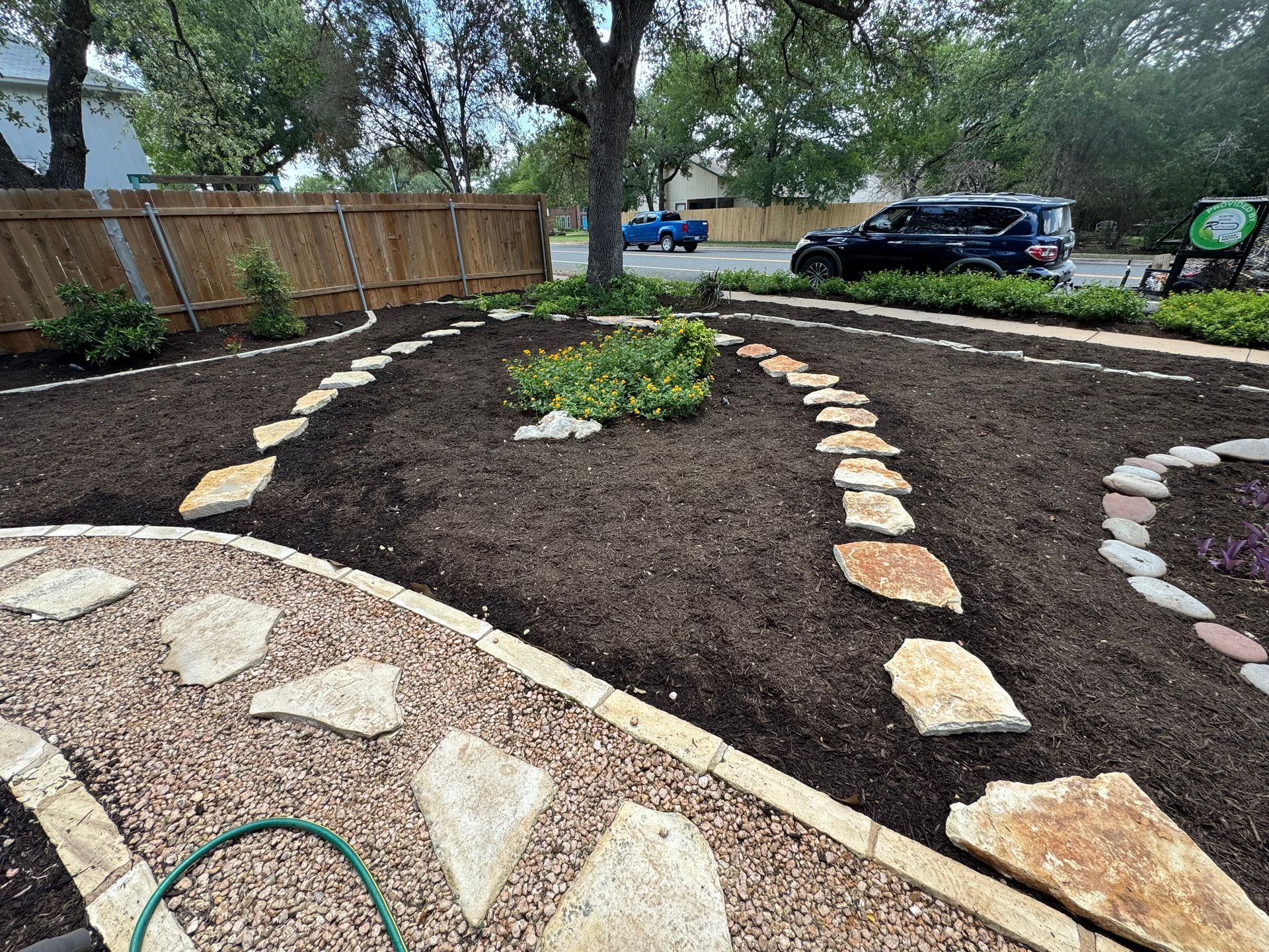 Landscaped backyard with stepping stones, mulch, and plants