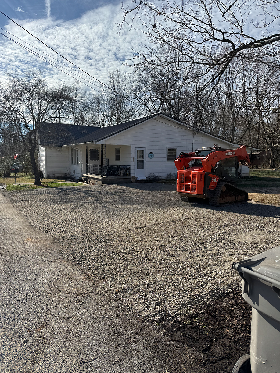 A house with a bulldozer parked in front of it.