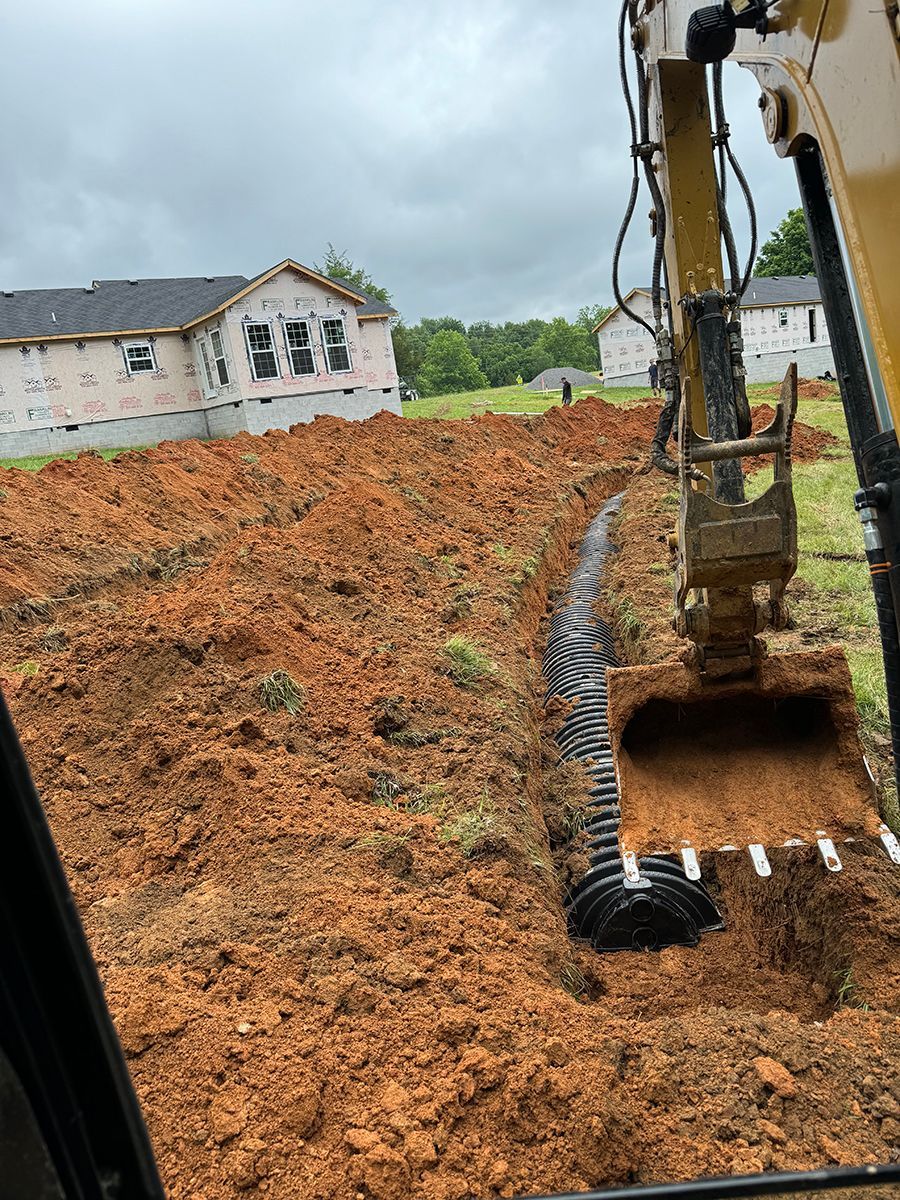 A bulldozer is digging a hole in the dirt in a field.