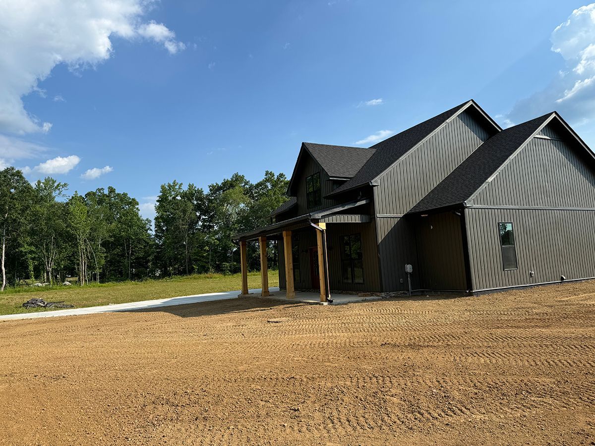 A house is being built in the middle of a dirt field.
