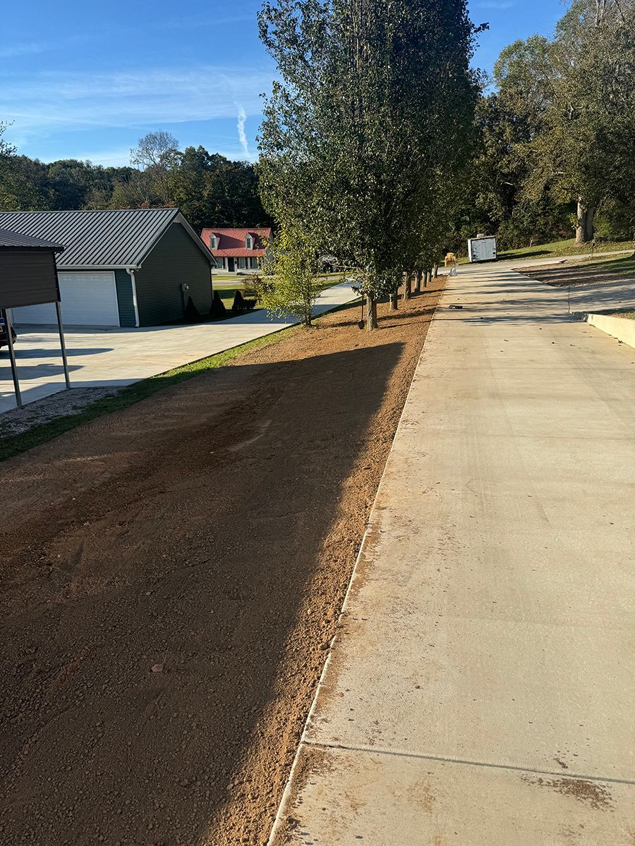 A concrete driveway with a house in the background.