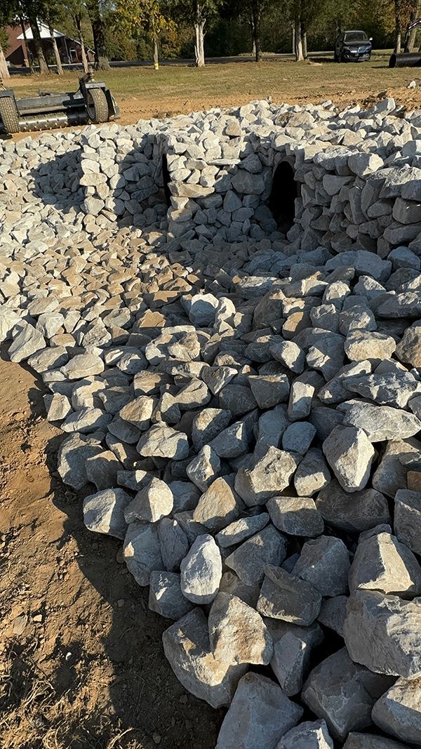 A pile of rocks sitting on top of a dirt field.
