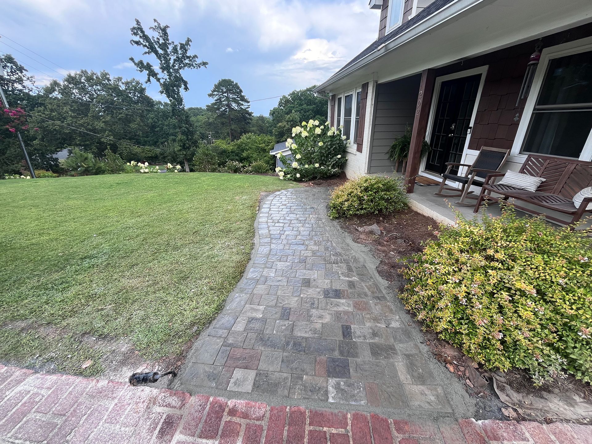 A brick walkway leading to the front of a house.