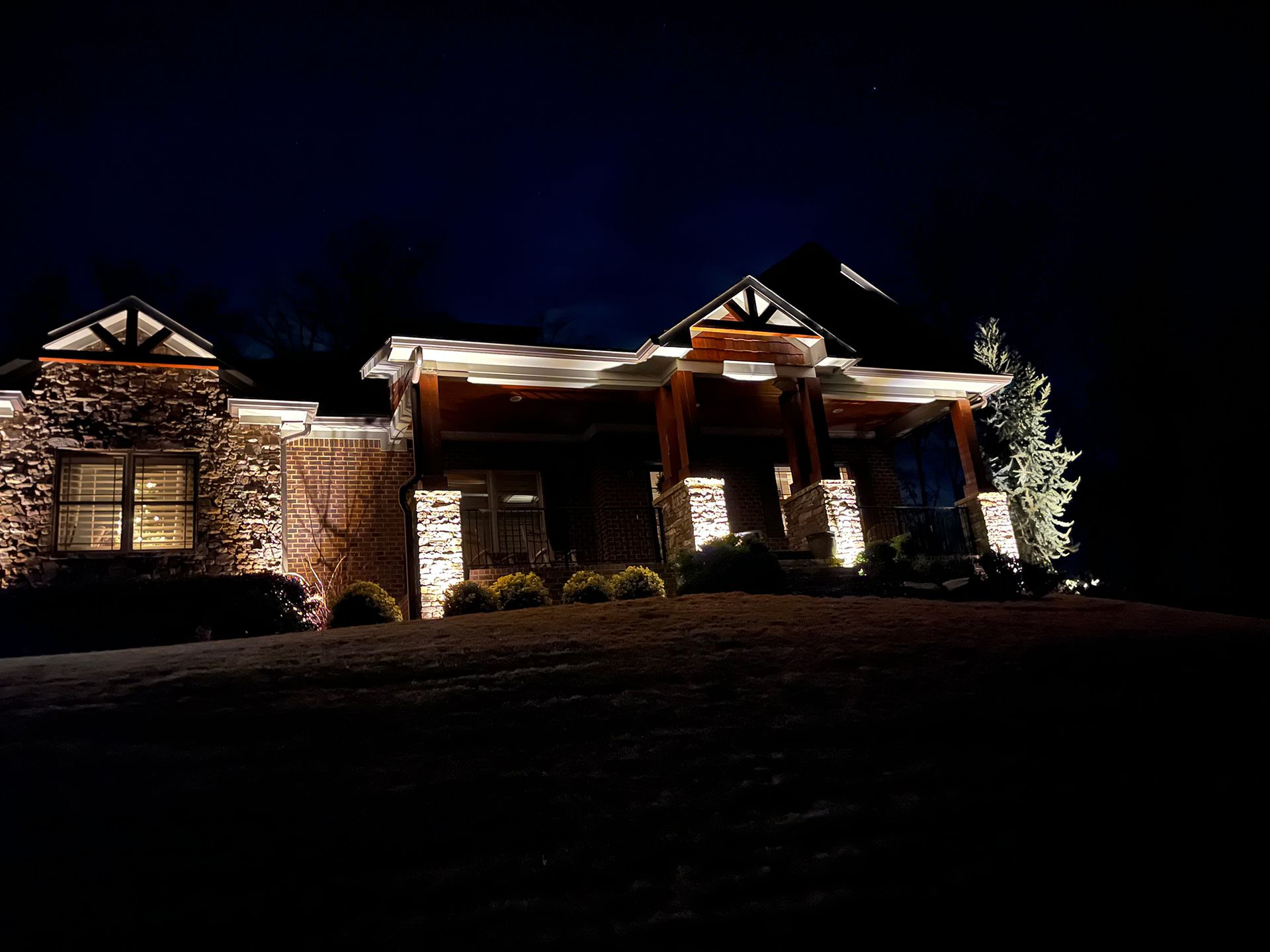 A large house is lit up at night with lots of lights.