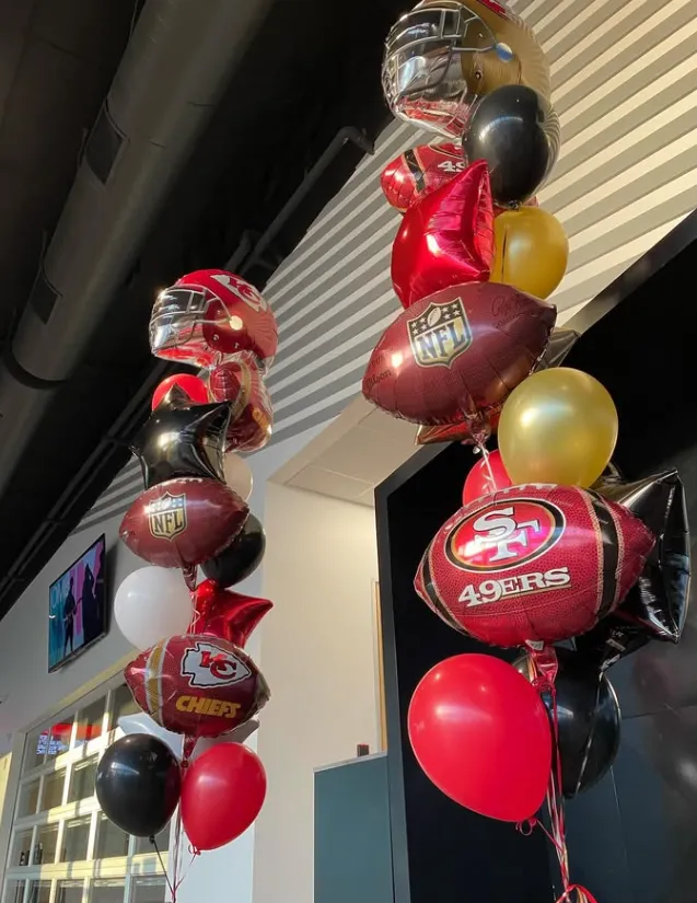 49ers-themed balloon columns in red, gold, black, and white at an outdoor entrance