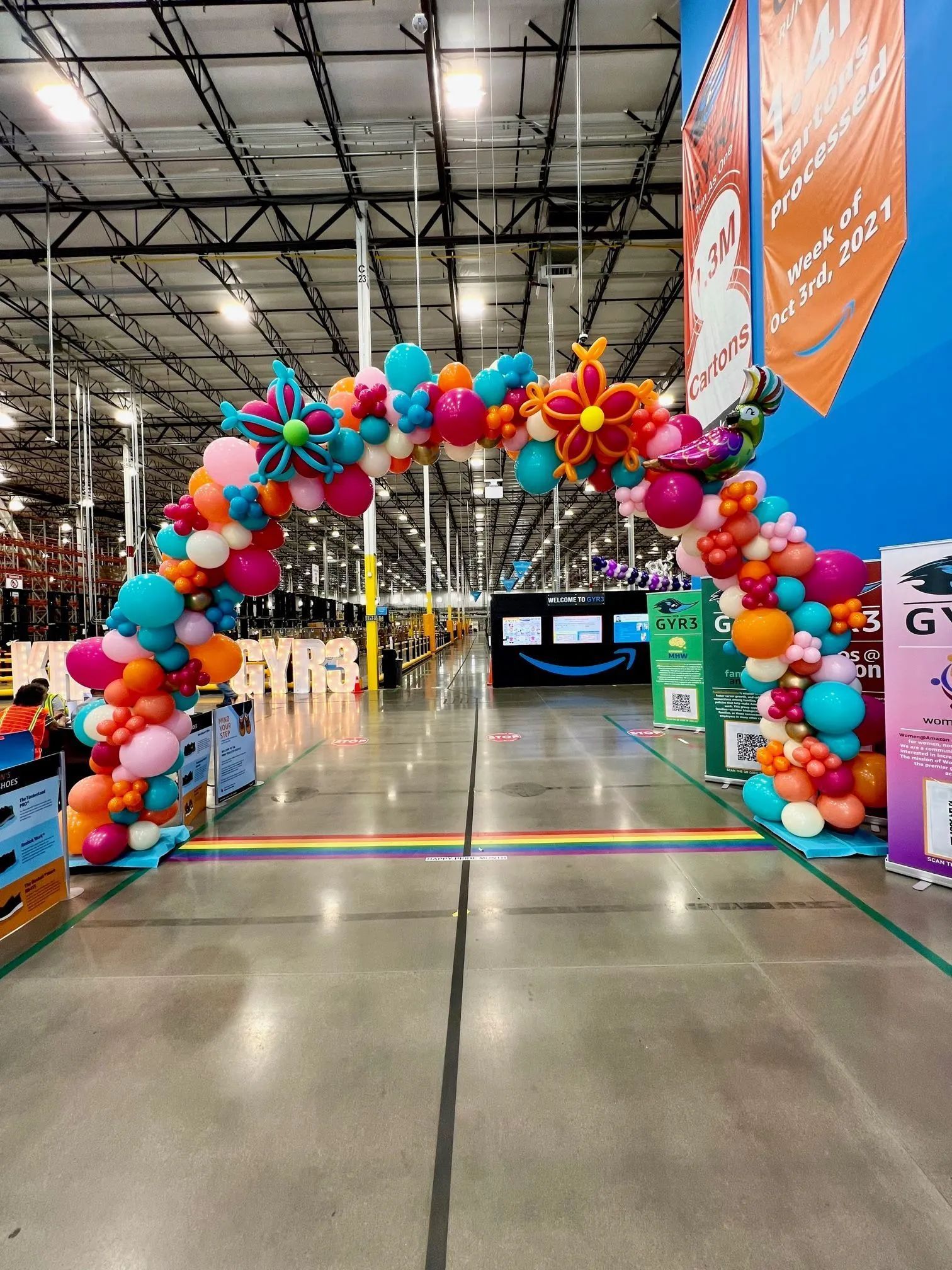 Colorful balloon arch over an aisle in a warehouse store or event space