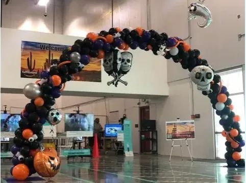 Halloween balloon arch with jack-o’-lanterns and skulls in a building lobby