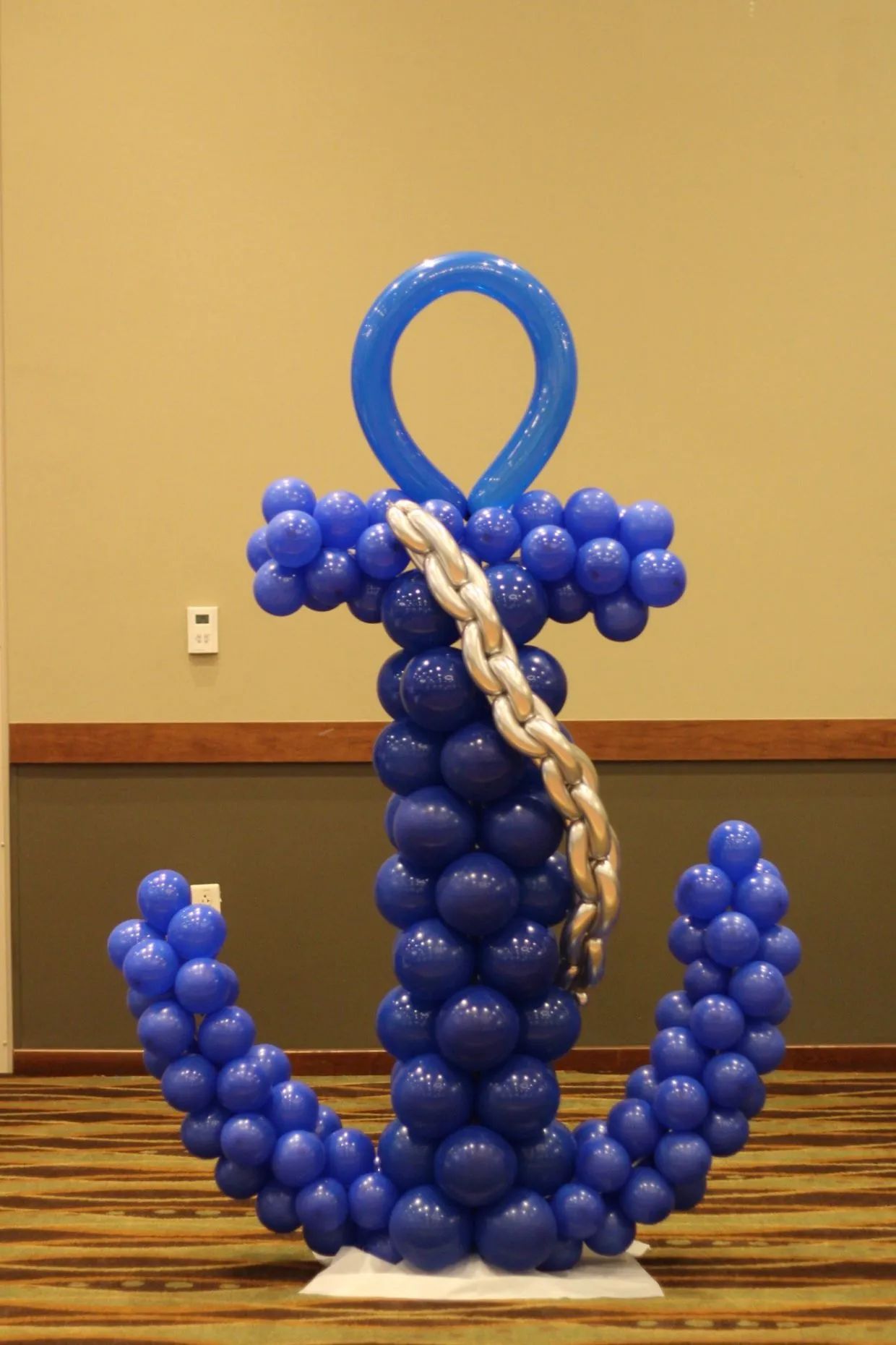 Blue balloon anchor sculpture with a white rope detail in a banquet hall