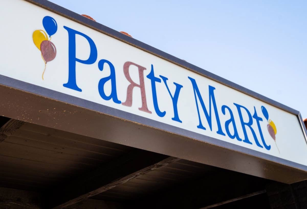 Party Mart storefront sign with blue lettering and balloon icons